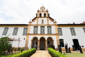 A historic building with a central entrance, arched doorways, and a bell tower.