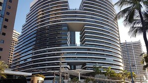 A modern, multi-story hotel with a curved facade and a central atrium. - Apto Beira-mar com Wi-fi e Piscina em Fortaleza (Fortaleza)
