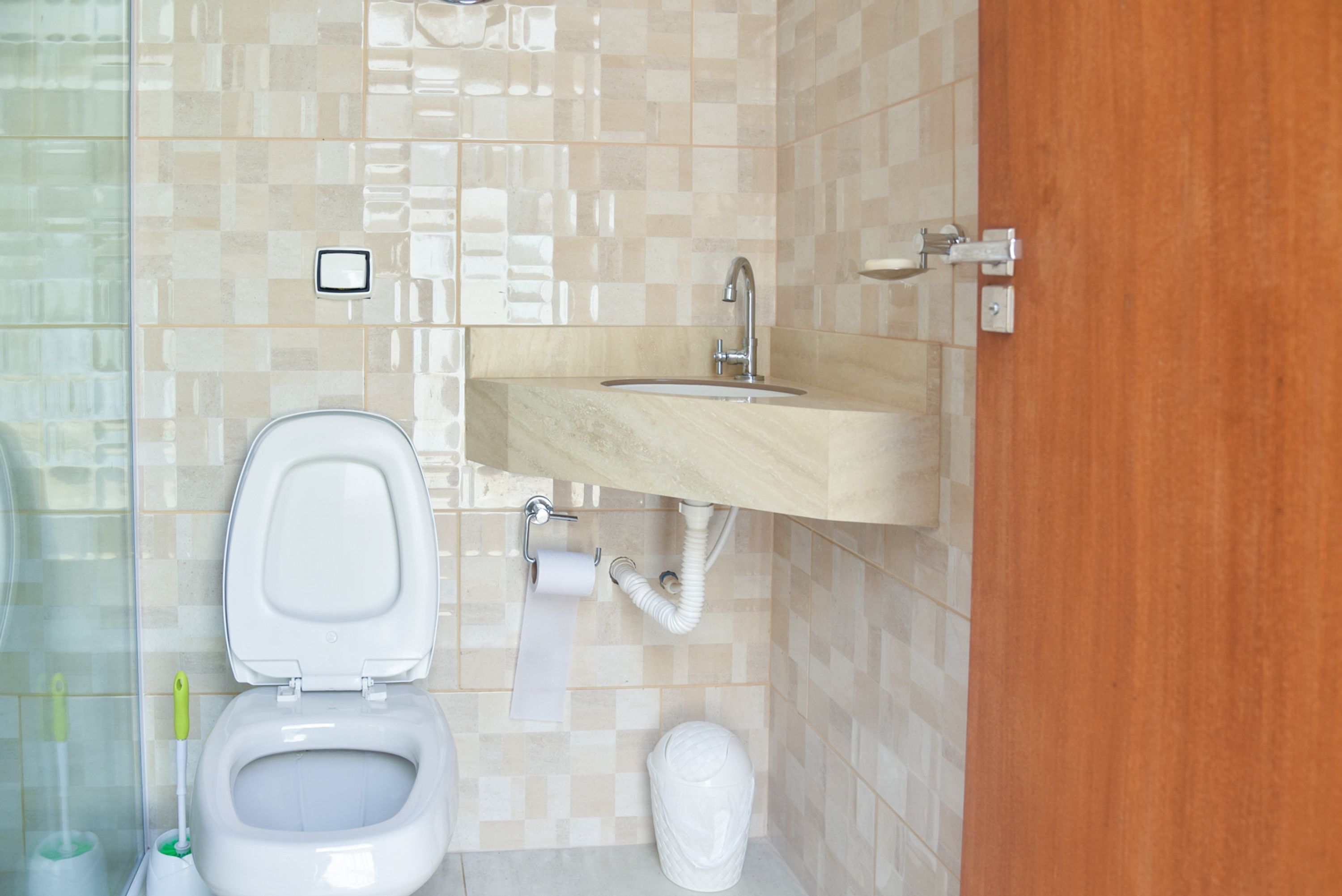 Une salle de bain équipée de toilettes, d’un lavabo et d’un porte-rouleau de papier toilette.
