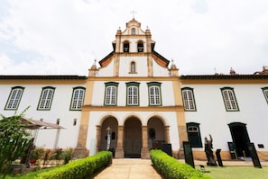 Un bâtiment de style colonial, doté d’une entrée centrale, de portes en arc de cercle et d’un clocher.
