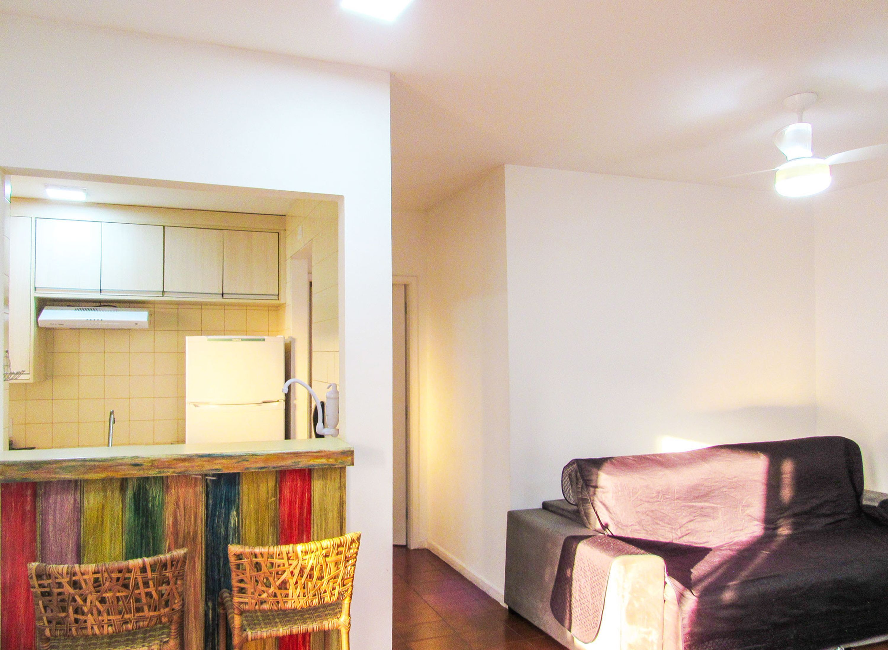 A compact living space with a kitchenette, a sofa, and a dining area with two chairs.