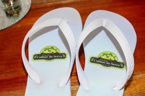 A pair of white flip-flops with a logo on the sole.