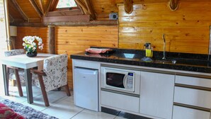 A compact kitchen with a microwave, sink, and a small refrigerator. - Chal com Wi-fi e Muito Lazer em Bom Retiro SC (Bom Retiro)