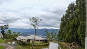 A rural landscape with a house, a pond, and a water wheel. - Chal com Wi-fi e Muito Lazer em Bom Retiro SC (Bom Retiro)