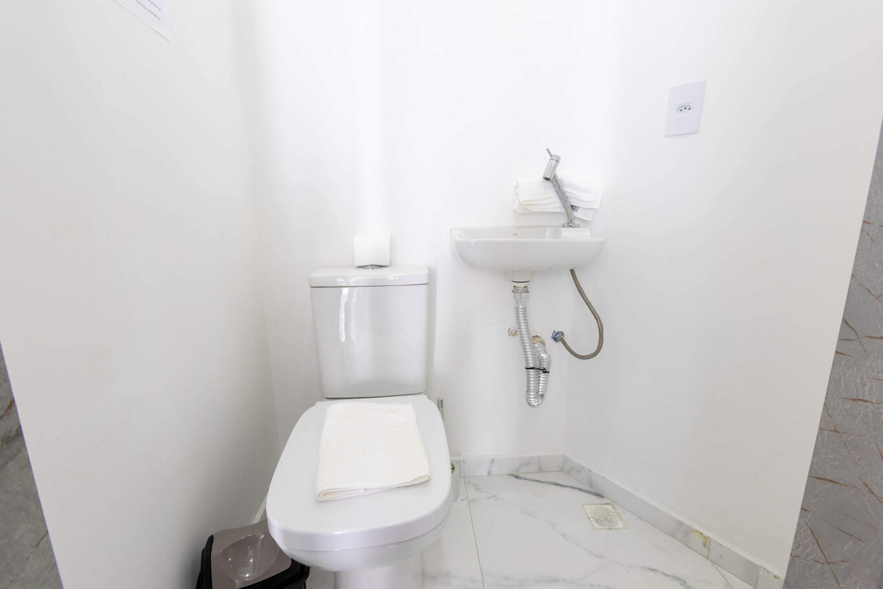 A small, clean bathroom with a toilet, sink, and shower.