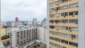A high-rise building with multiple floors, balconies, and a parking area in the foreground. - Apto com Wifi e Tima Localiza o Laranjeiras RJ (Rio de Janeiro)