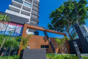 A modern building with a wooden facade, large windows, and a sign reading "HUB". - Studio Elegante com Varanda e Tima Localiza o (São Paulo)