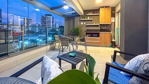A modern apartment with a balcony, a kitchen area, and a seating area with a view of the city. - Excelente Apto a 50m do Metr Butant em S o Paulo (São Paulo)