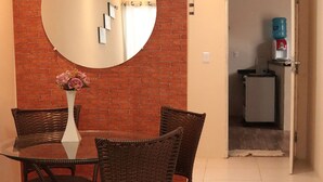 A dining area with a round table, wicker chairs, a mirror, and a vase with flowers. - Casa c Wifi e Tima Localiza o em Barreirinhas MA (Barreirinhas)