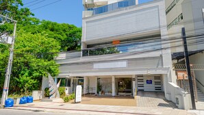 A modern multi-story building with a covered entrance and a staircase leading to the upper floors. - Apartamento Completo em Trindade Perto da Ufsc (Florianópolis)