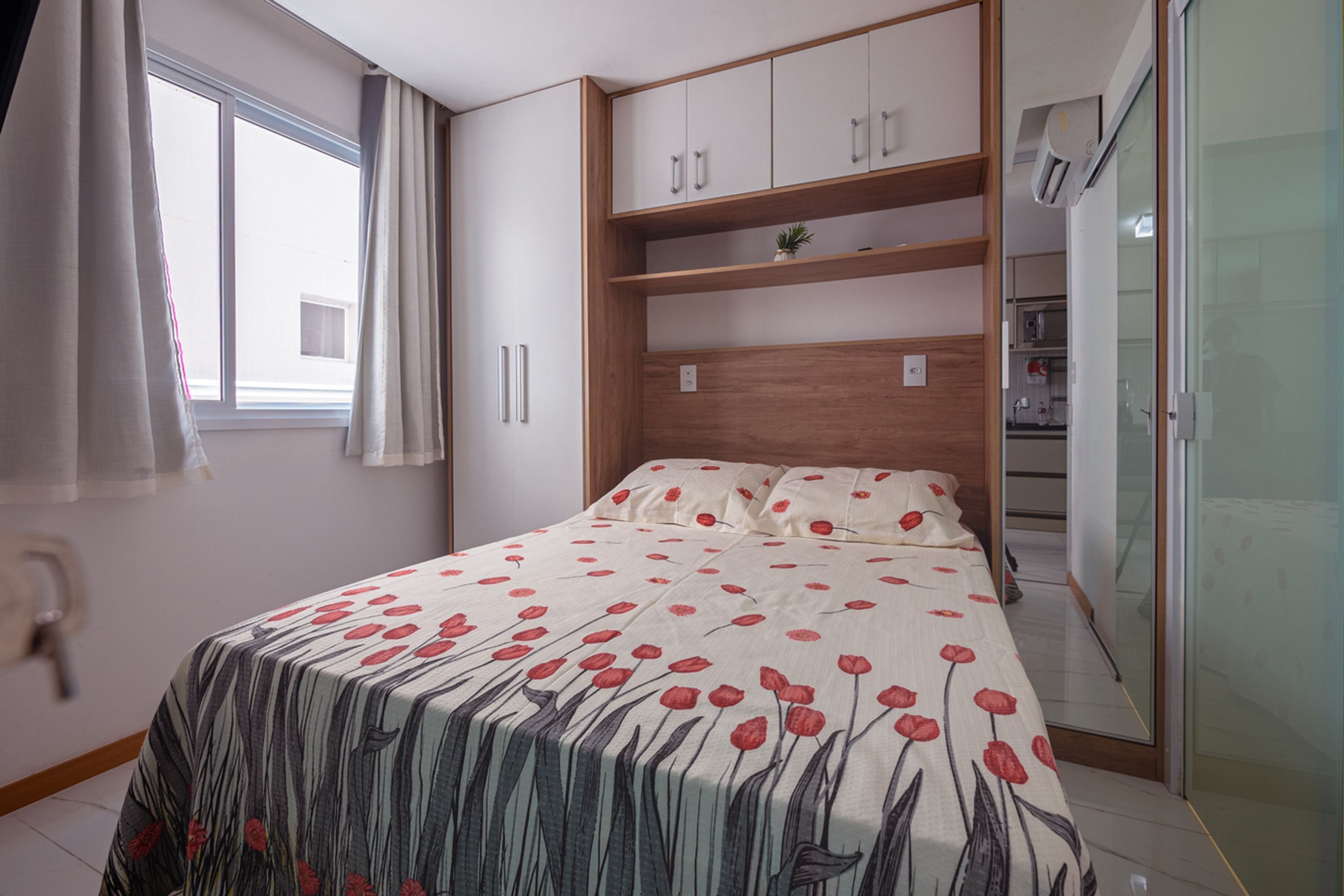 A bedroom with a bed, a wardrobe, a window, and a door.