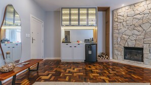 Una cocina moderna con armarios blancos, lavavajillas integrado y una chimenea de piedra.