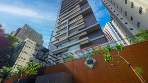 Un moderno edificio de gran altura con fachada de vidrio, rodeado de otros edificios.