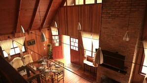 Un intérieur chaleureux et rustique, avec un espace repas, une cheminée et un téléviseur.