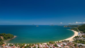 A coastal town with a beach, clear blue waters, and lush greenery. - Casa c Piscina a 150m da Praia de Boi Ucanga (São Sebastião)