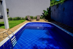 A swimming pool with a tiled edge, two lounge chairs, and a ladder. - Casa c Piscina a 150m da Praia de Boi Ucanga (São Sebastião)