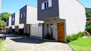 Un edificio residencial moderno con entrada pavimentada, garaje y césped cuidado.