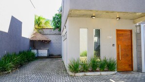 Un edificio moderno con un camino de ladrillo que lleva a una puerta de madera con el número 07.