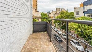 A balcony with a view of parked cars and buildings. - Casa Triplex com Tima Localiza o Pet Friendly (Porto Alegre)
