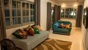 A living room with a sofa, a chair, and a fan. - Casa c Tima Localiza o em Teixeira de Freitas-ba (Teixeira de Freitas)