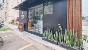 A modern building with a sign indicating it is open 24 hours. - Flat Confort vel com Wi-fi em Santa Cruz RJ (Rio de Janeiro)
