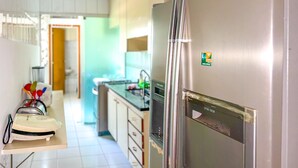 A kitchen with a stainless steel refrigerator, a microwave, and a coffee maker on the counter. - Apto Espa oso c Wifi pr x a Marginal Pinheiros SP (São Paulo)