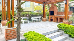An outdoor patio with a brick barbecue, wooden benches, and a pergola structure. - Apto Espa oso c Wifi pr x a Marginal Pinheiros SP (São Paulo)