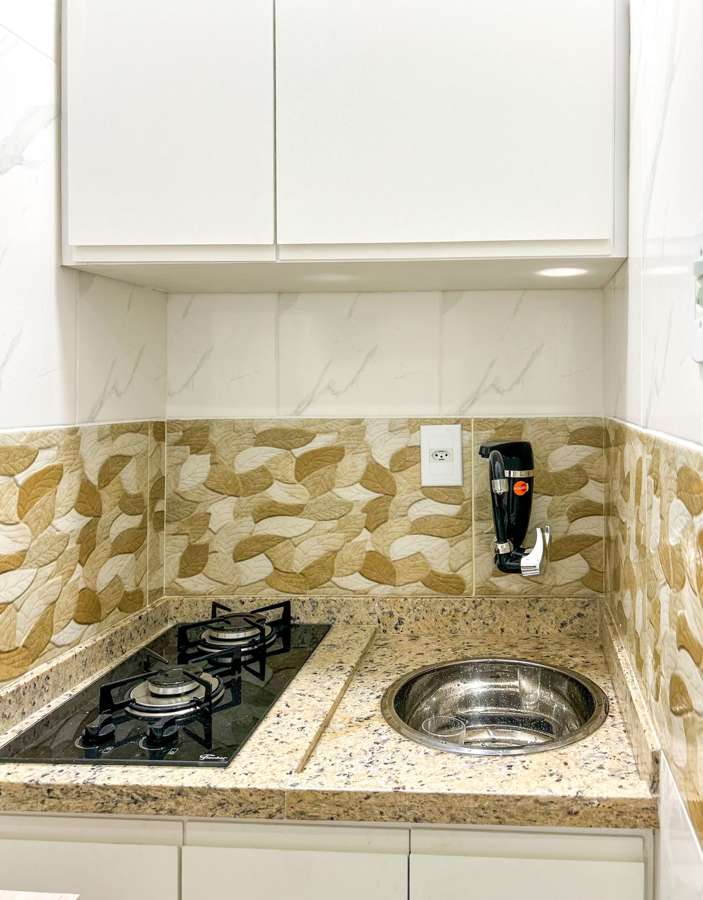 A kitchen with a gas stove, a sink, and a coffee machine.
