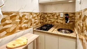 A compact kitchen with a gas stove, a sink, and a countertop with a cutting board. - Timo Studio c Wifi a 190m da Praia do Leme RJ (Rio de Janeiro)