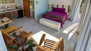 A spacious room with a large bed, a dining area with wooden furniture, and a kitchen area. - Cabana com Jacuzzi e Churrasqueira - Ibi na SP (Ibiuna)
