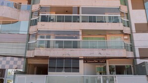 Un edificio de varios pisos con un diseño moderno, que cuenta con balcones y ventanas amplias.