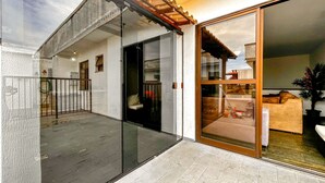 A modern house with a glass door leading to a patio area. - Incr vel Apto a 800m da Praia do Forte - Cabo Frio (Cabo Frio)