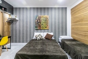 A modern bedroom with a bed, two bedside tables, a chair, and a painting on the wall. - Loft pr x do Aeroporto no Centro e com Wi-fi (Rio de Janeiro)