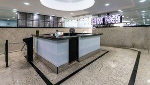 A modern reception area with a marble floor, a central island counter, and a ceiling light fixture. - Loft pr x do Aeroporto no Centro e com Wi-fi (Rio de Janeiro)