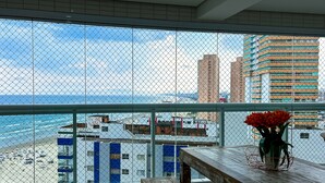 A balcony with a view of the beach and cityscape. - Timo Apto de Frente Para Praia do Boqueir o SP (Praia Grande)