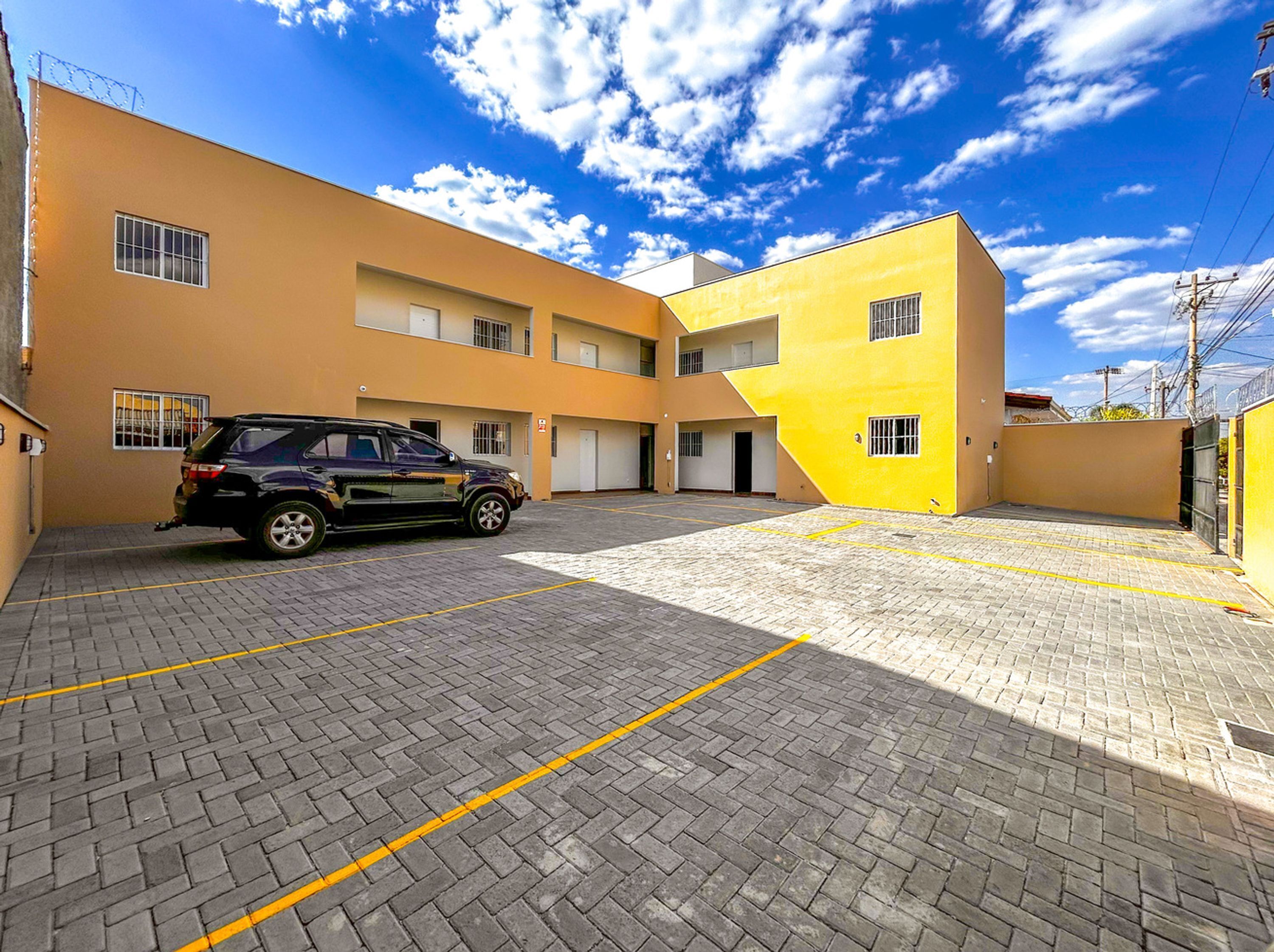 A parking area with a paved surface and a vehicle parked.