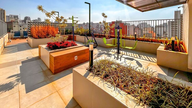 A rooftop terrace with outdoor seating, exercise equipment, and planters with various plants. - Apto Confort vel com Wifi no Centro da Bela Vista (São Paulo)
