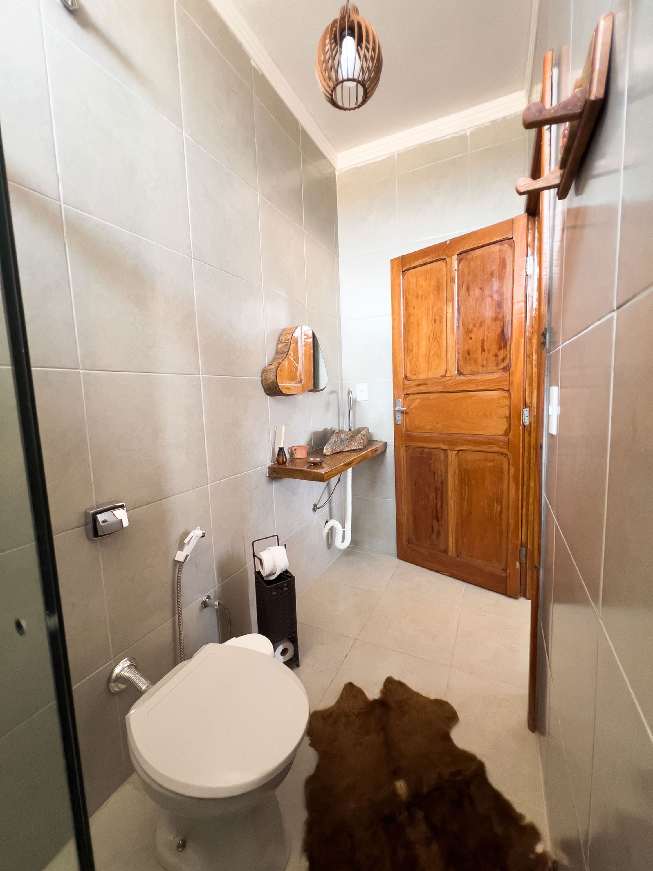 Un bagno con il water, doccia e una porta in legno.