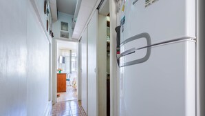 A narrow hallway with a tiled floor leading to a kitchen area. - Timo Apto com Wi-fi a 350m da Praia de Copacabana (Rio de Janeiro)