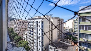 A view through a chain-link fence of a densely packed urban area with high-rise buildings, some with satellite dishes. - Timo Apto com Wi-fi a 350m da Praia de Copacabana (Rio de Janeiro)