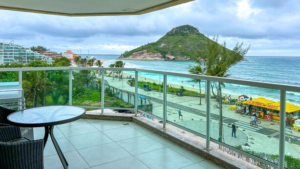 A balcony with a view of a beach and ocean.