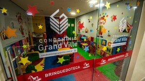 Een kleurrijk speelgedeelte voor kinderen met een sterrenhemel en een bordje met de tekst 'CONDOMÍNIO Grand Ville'.