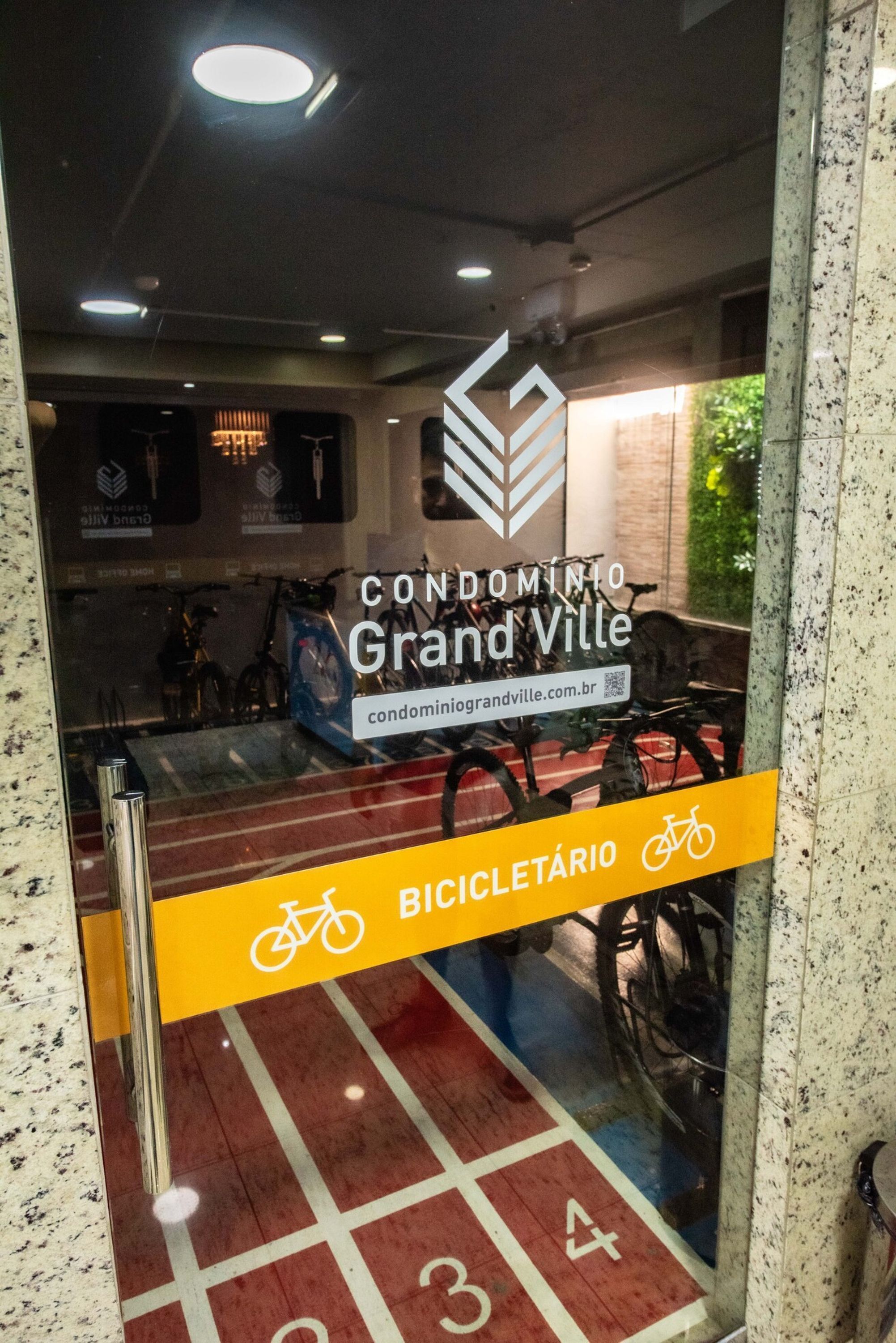 Vista de un aparcamiento para bicicletas con un cartel que indica que forma parte del Condomínio Grand Ville.