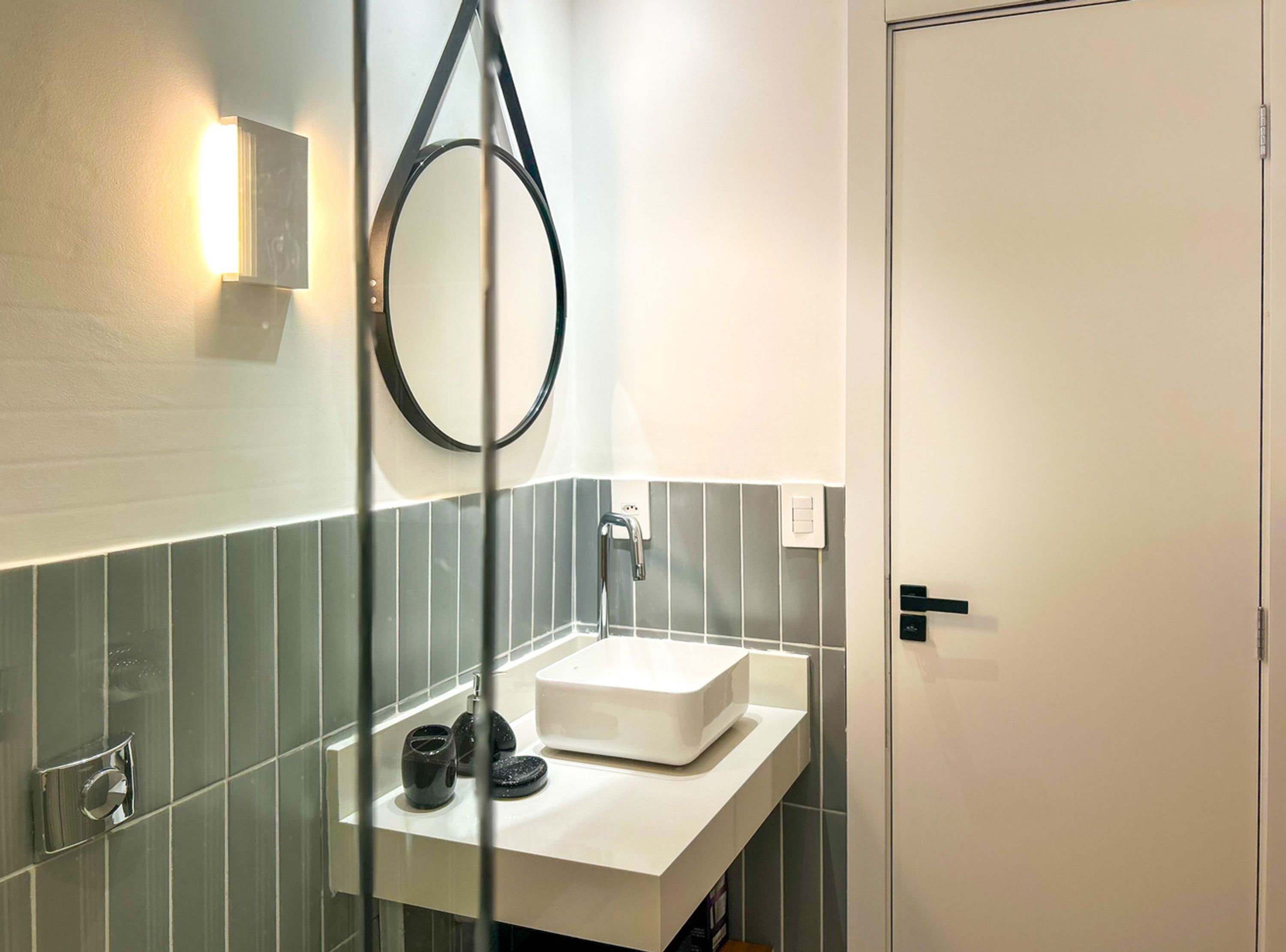 A modern bathroom with a white sink, a mirror, and a towel rack.