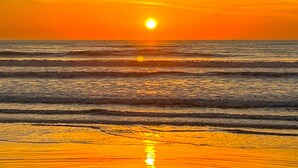A sunset over the ocean with calm waves. - Casa a Poucos Metros da Praia do Coral - Cabo Frio (Cabo Frio)