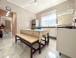 A compact kitchen with a bench, a refrigerator, and a window. - Casa c Tima Localiza o e Wi-fi em Bertioga SP (Bertioga)