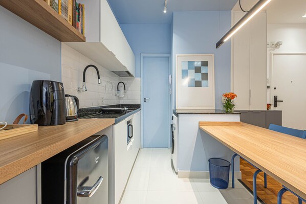 Una cocina moderna con encimera de madera, lavavajillas integrado y un fregadero.
