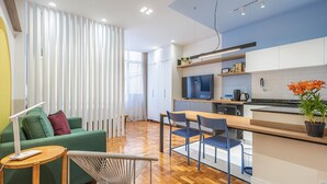 Une cuisine moderne dotée d’un plan de travail en bois, d’un four encastré et d’un évier. On y trouve également un coin repas avec une table et des chaises en bois.