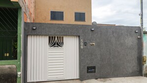 A building with a grey exterior, a white garage door, and two small windows on the upper level.