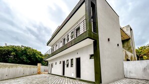 Un bâtiment moderne à deux étages, doté d’un toit plat, de grandes fenêtres et d’un balcon.